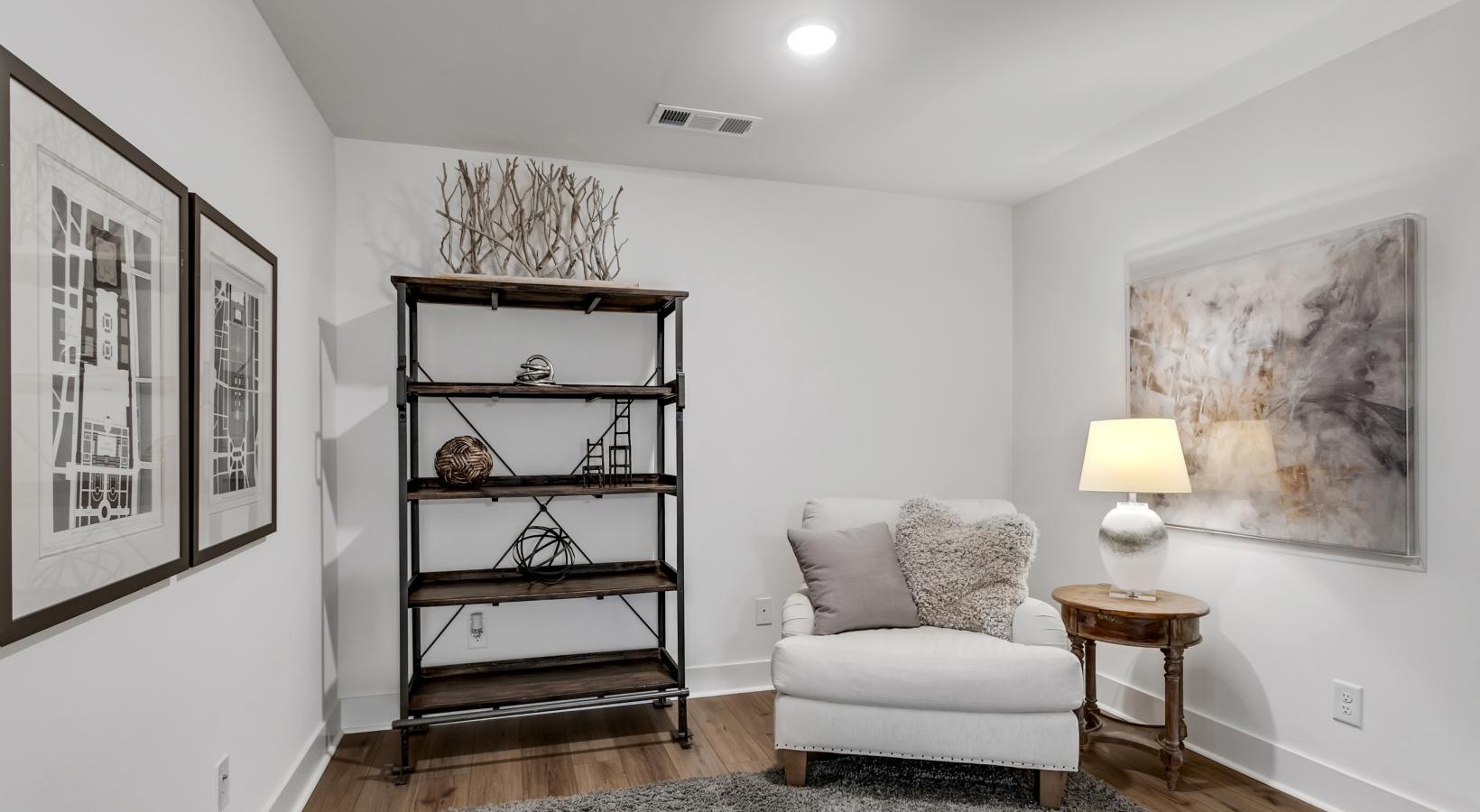 Beautiful bedrooms to fit every need a room with a white chair and a book shelf with art on it