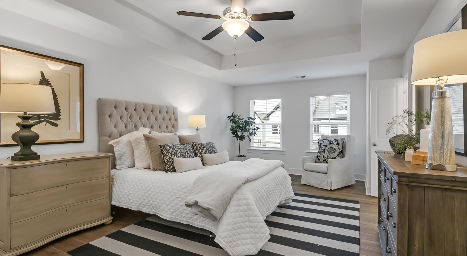 Relax and recharge in beautiful and spacious bedrooms a bedroom with a bed and a fan