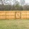 a backyard with grass and wood fence